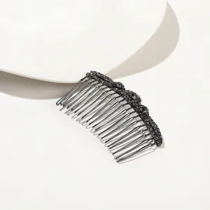 Detailed view of a vintage black alloy hair comb featuring dark grey multifaceted rhinestones
