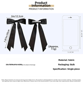 Detail of black satin double bow hair clip with metal spring fastener mechanism