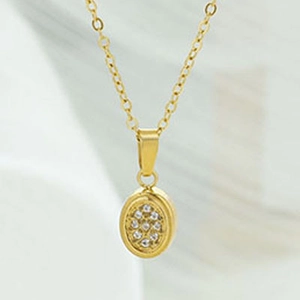 Detail view of a gold oval pendant necklace with shimmering micro-paved zircon crystals