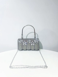 Close-up of silver rhinestone evening bag with elegant fringe and metal chain strap