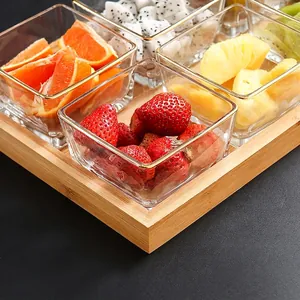 Nordic transparent glass square bowls set with a raised bamboo serving tray and gold trim