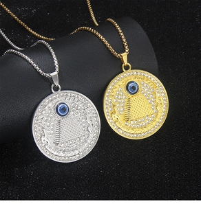 Close-up of gold and silver pyramid eye necklaces with crystal pave on black background