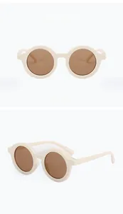 Vista frontale e laterale di occhiali da sole rotondi beige per bambini con lenti marroni
