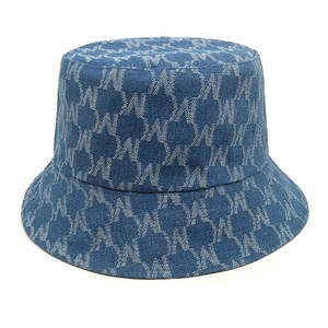 Detailed close-up of blue denim bucket hat with woven letter M pattern texture