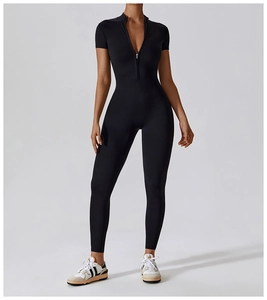 Detailed view of black short sleeve yoga bodysuit featuring a metallic front zipper closure
