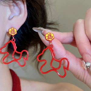 Detail of red enamel horse-shaped earrings with Fu character in neo-Chinese style