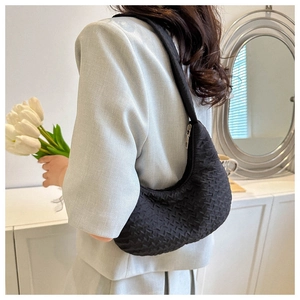 Detailed view of black bubble-textured crossbody bag with silver zipper closure