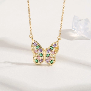 Collier papillon doré avec pendentif en zircone multicolore sur un fond texturé