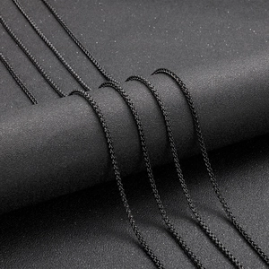 Macro shot of black titanium steel wheat chain texture on dark matte cylinder base