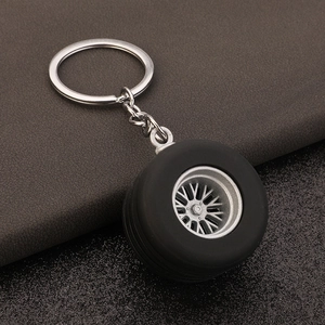 Macro detail of 3D car tire keychain showing realistic rubber treads and silver alloy rim