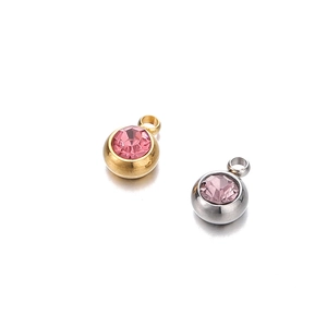 Gros plan de pendentifs en acier inoxydable 6mm or et argent avec zircones roses