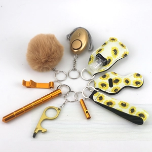 Flat lay of sunflower theme safety keychain set with gold alarm and plush pom pom