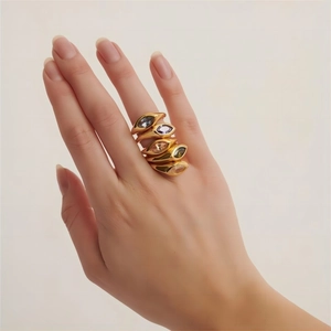 Macro detail of five vintage 18K gold-plated rings set with marquise-cut colored crystals