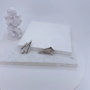 Detail of silver lightning bolt earring with pavé zircon crystals on artistic background