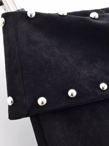 Detailed macro view of black suede fabric texture with metallic silver rivet studs