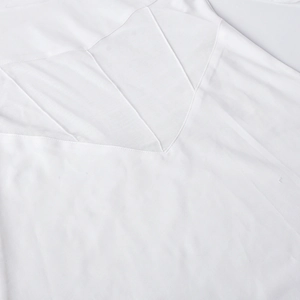Détail des coutures en maille blanche et de la texture du tissu sur la robe à manches longues