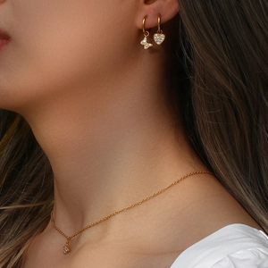 Close-up of elegant gold butterfly necklace and earrings set with cubic zirconia on model