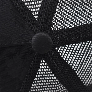 Detailed macro view of black mesh and fabric stitching on the crown of a baseball cap
