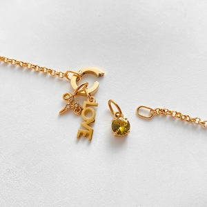 Detailed view of 14K gold-plated bracelet featuring LOVE charm and yellow zircon