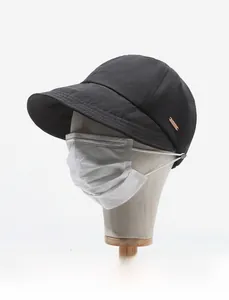 Détail du chapeau de soleil noir avec boucle latérale pour masque et logo en bronze