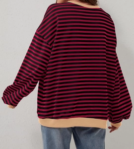 Dettaglio del retro di una felpa a righe rosse e nere con bordi a costine color beige