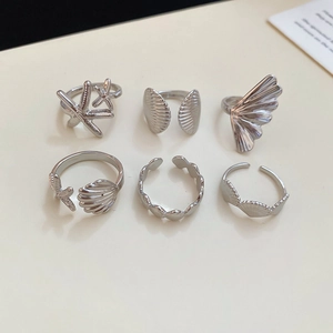 Detailed view of silver sea star and shell themed ring set with metallic ocean motifs