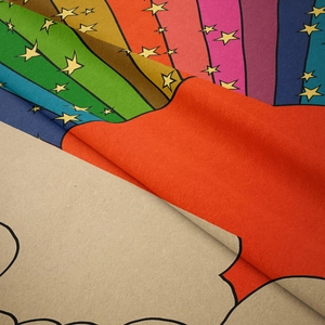 Close-up of bohemian rainbow tapestry fabric showing textile texture and cartoon pattern