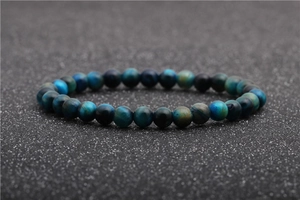 Close-up detail of blue tiger eye stone beads with natural silk texture on a dark background
