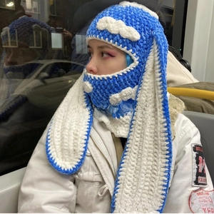 Detail of blue and white knitted balaclava with long rabbit ears and cloud patch