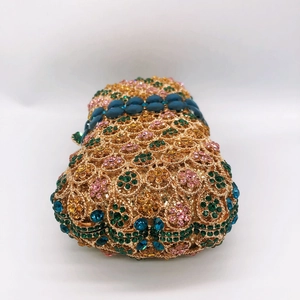 Macro view of crystal flower hollowed out gold evening bag with luxury colorful stones