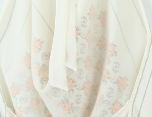 Macro detail of satin texture floral print with pink flowers and tie-neck detail