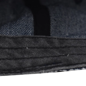 Detailed macro view of triple stitching on high-quality dark blue washed denim baseball cap