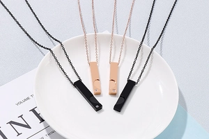 Détail de colliers pour couple avec pendentifs noirs et or rose et découpes en cœur