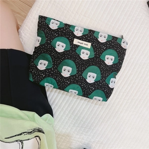 Detail of canvas pouch showing green hair lady pattern and simple wish woven label
