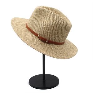 Classic Panama straw hat with brown leather belt and gold buckle on a minimalist stand