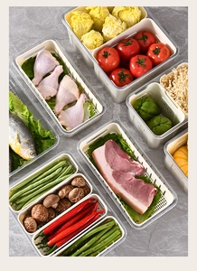 Macro shot of clear plastic food containers with white drainage baskets on marble
