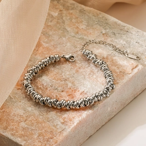 Silver stainless steel thick twist chain bracelet displayed on a pink stone block