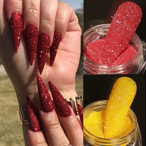 Dettaglio macro della polvere glitterata riflettente rossa e gialla per decorazione unghie
