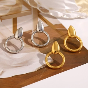 Detail of 18K gold and silver water drop earrings on elegant silk fabric background