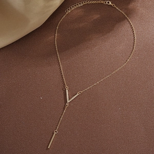 Elegant gold-tone titanium steel V-shape long Y-necklace for women on leather background
