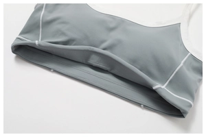 Close-up of the grey-blue yoga top showing white contrast piping and fine stitching detail