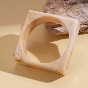Detail of cream marble resin square bangle featuring retro tortoiseshell pattern texture