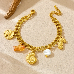 Bracelet doré thème océan avec pendentifs hippocampe, coquillages et perles marines