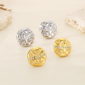 Macro detail of textured gold and silver button earrings with clear rhinestone inlay