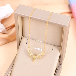 Elegant gold angel wing necklace with white rhinestones in a luxury jewelry box