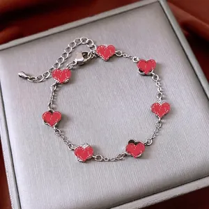 Silver bracelet featuring seven red heart pendants with vintage beaded edge detailing