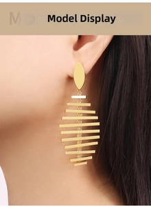 Close-up of geometric fishbone earrings in 18K gold plated titanium steel on a model