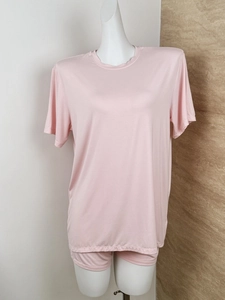 Detail of soft pink lounge set showing knit texture on a mannequin with two-tone background
