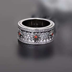 Macro view of a gunmetal gear ring featuring red stones and white zircon stones pavé