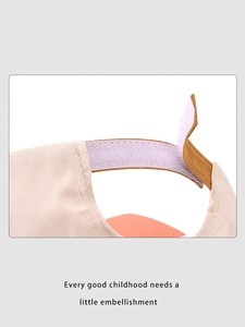 Detail of adjustable velcro closure with brown trim on a cotton kids baseball cap